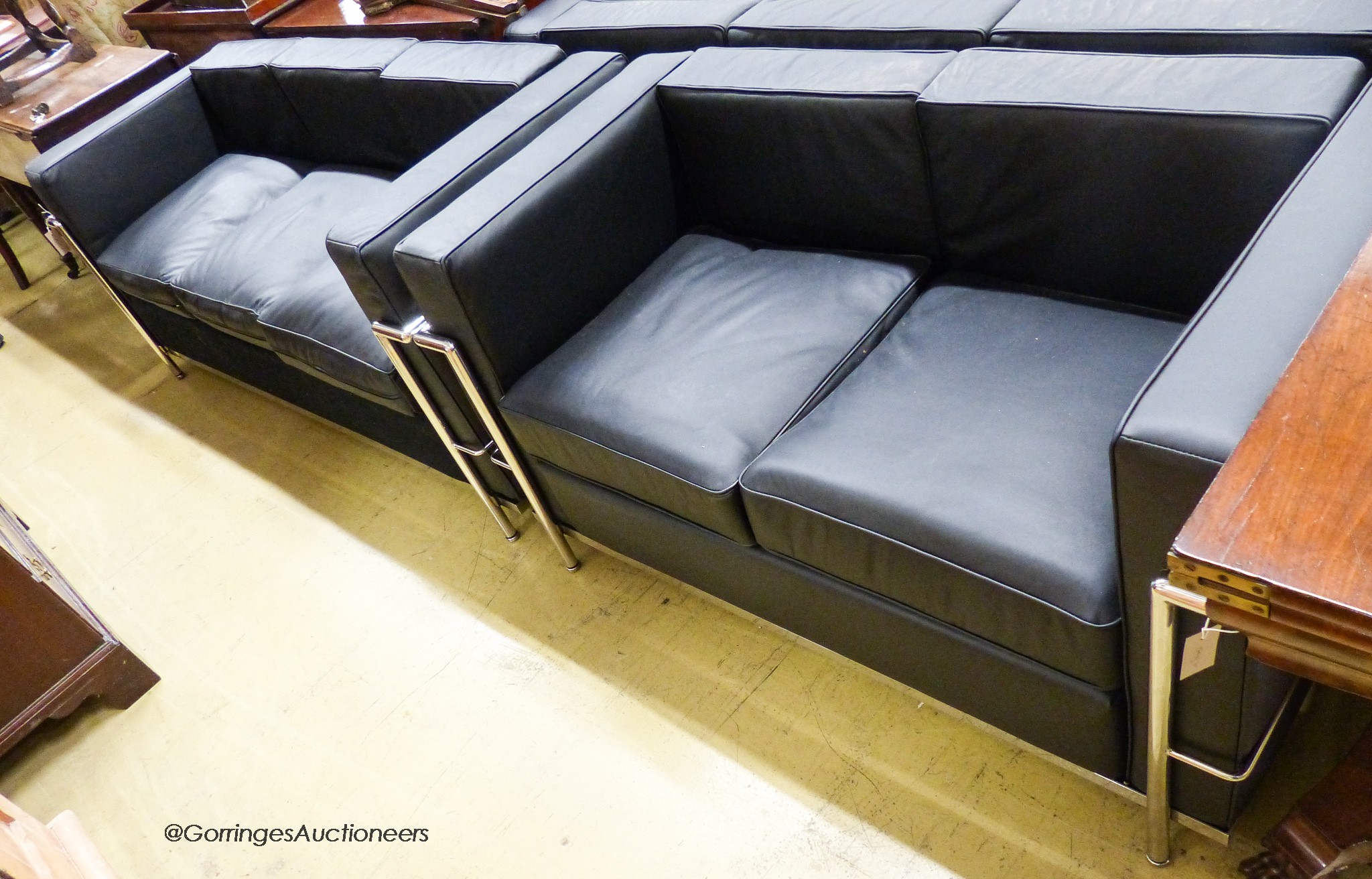 A Corbusier style black leather and chrome three seater and two seater settee, larger length 180cm, depth 70cm, height 69cm